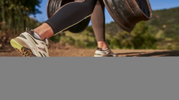 Person exercising outdoors in white and grey Reebok shoes.
